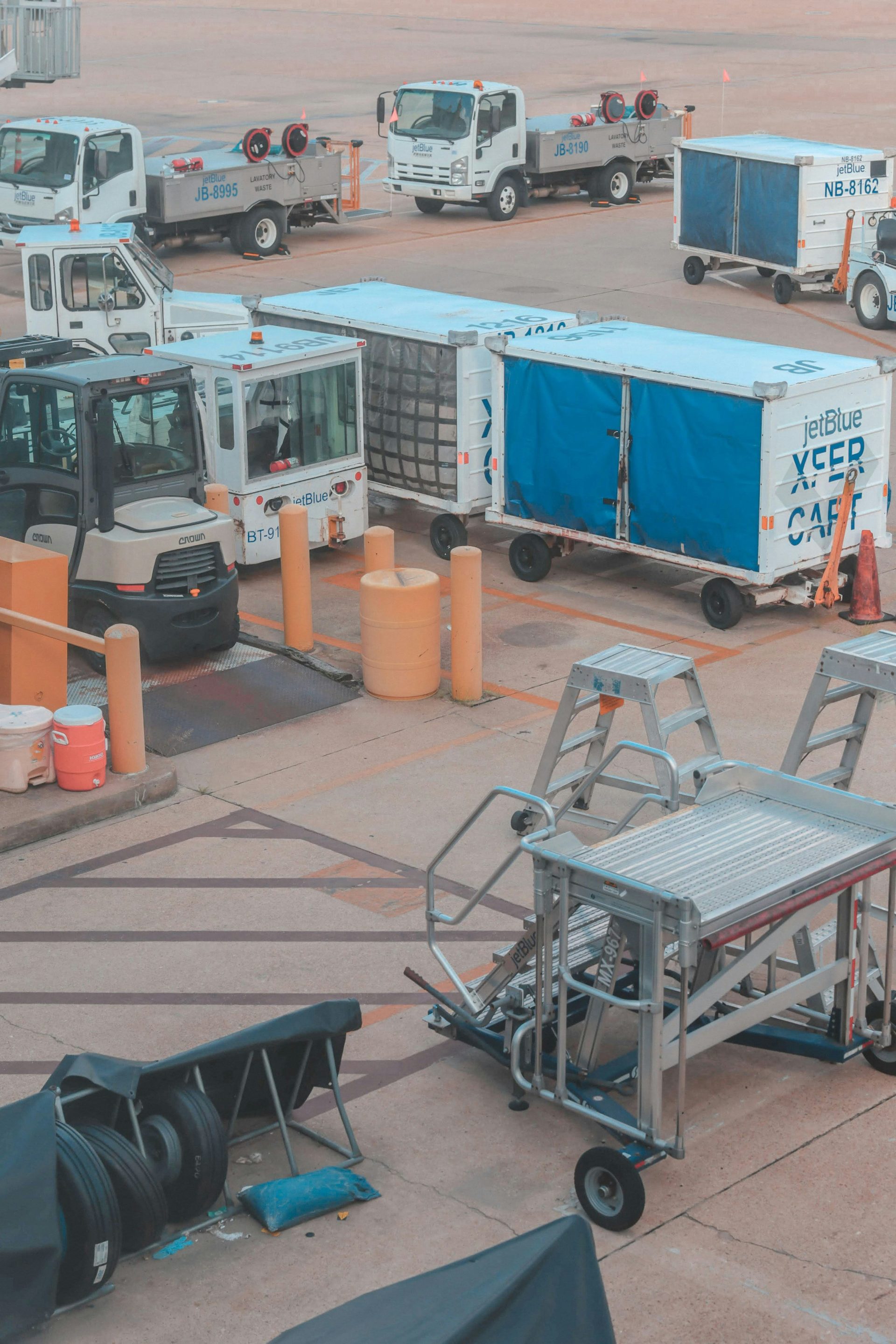 Airport vehicles and equipment are parked on a ramp.