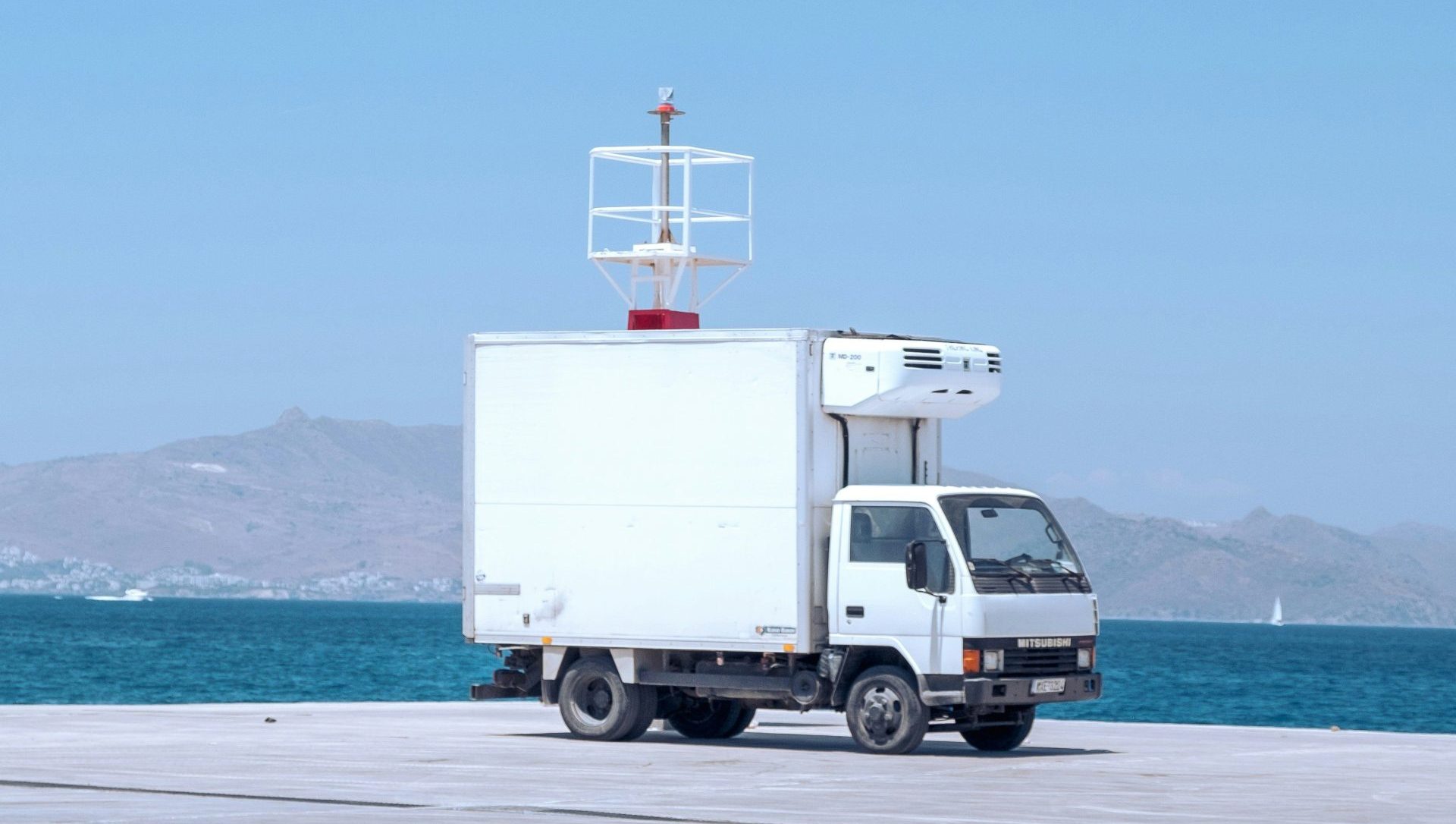 a truck is parked on the beach near the water